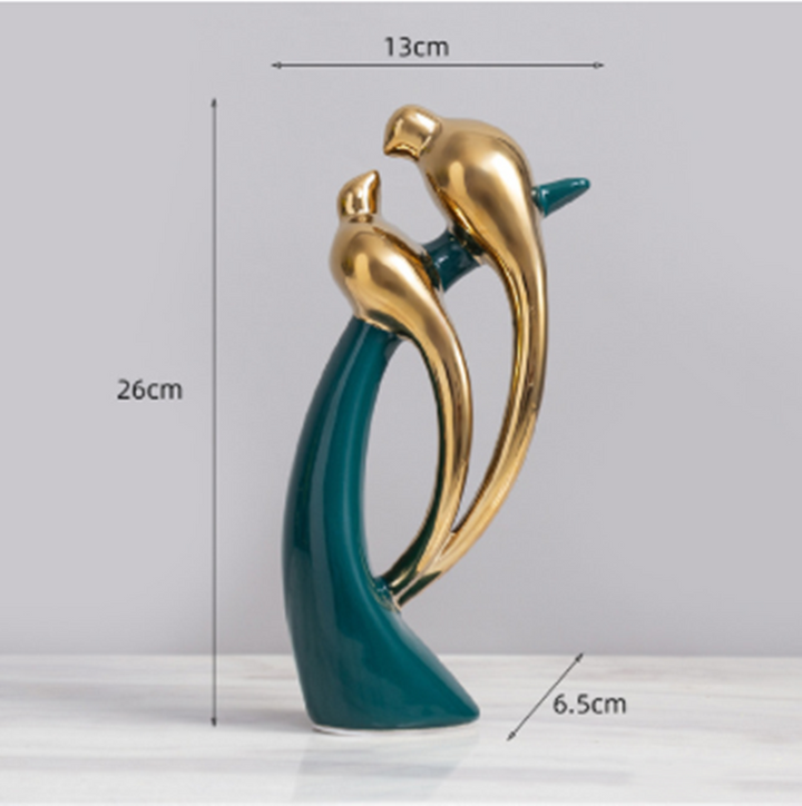 Detaljeret love birds figur i guld med smaragdgrønne accenter. Moderne kunst og håndlavet dekoration.