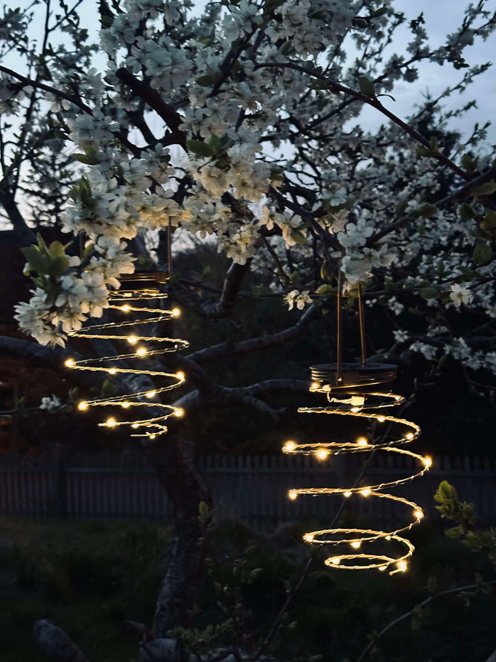 Dekorativ gylden metal solcelle lampe med spiral design til haven. Miljøvenlig LED lanterne skaber stemning.