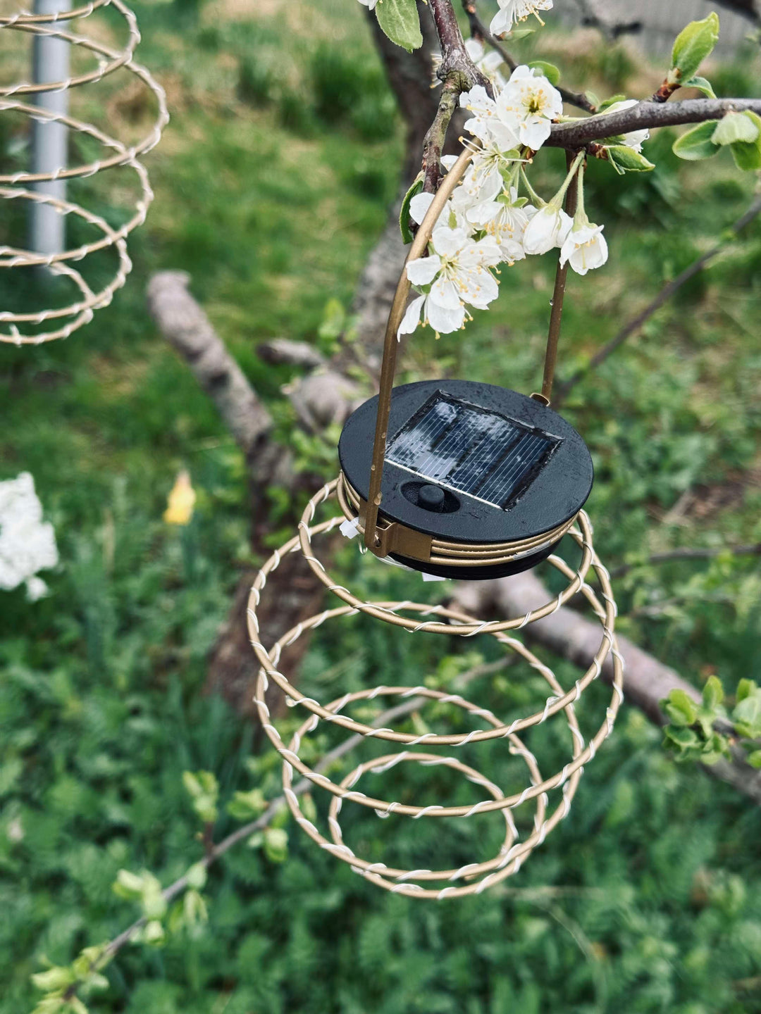 Nærbillede af gylden solcelle spiral lampe med varmt LED lys. Ideel have dekoration der skaber hyggelig stemning.