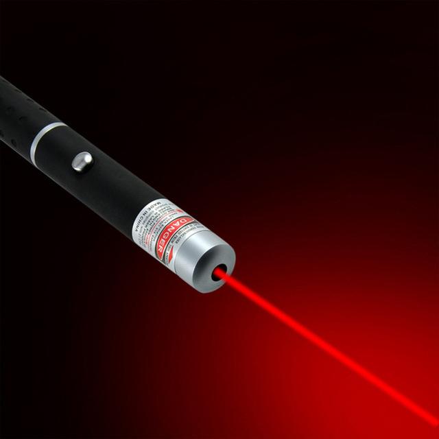 Detaljebillede af en laserpointer, der udsender en skarp, synlig laserlys-stråle i mørket.
