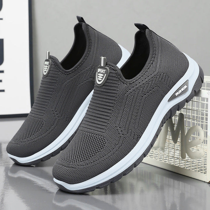 Herre åndbare slip-on sneakers med fleksibel strik-overdel for komfort og sporty look. Perfekt til hverdagsbrug, sort farve.