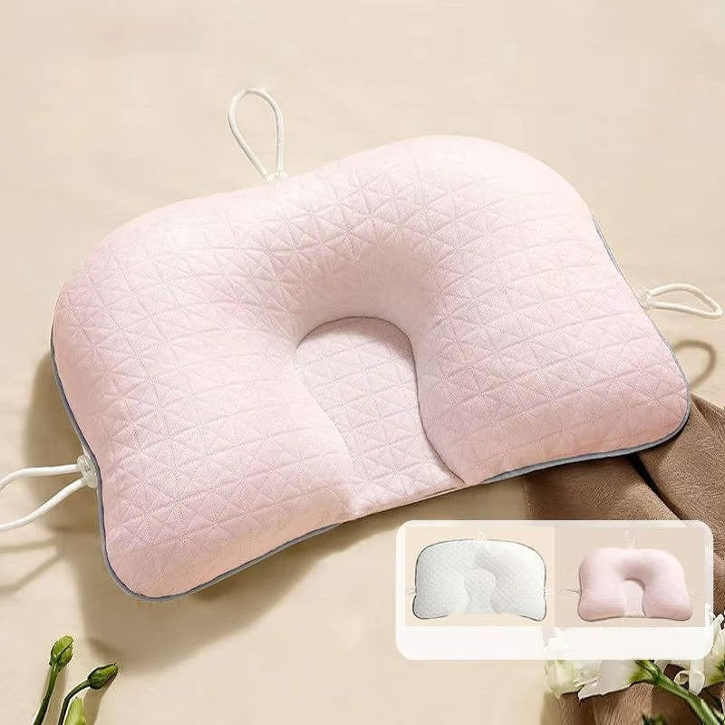 Lyserød ergonomisk baby hovedpude for optimal komfort og forebyggelse af fladt hoved syndrom hos spædbørn.