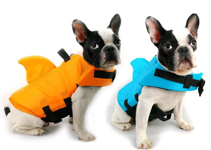 Hundesvømmevest med hajfinne i blåt stof, justerbare stropper for optimal sikkerhed i vandet, egnet til hunde i alle størrelser.