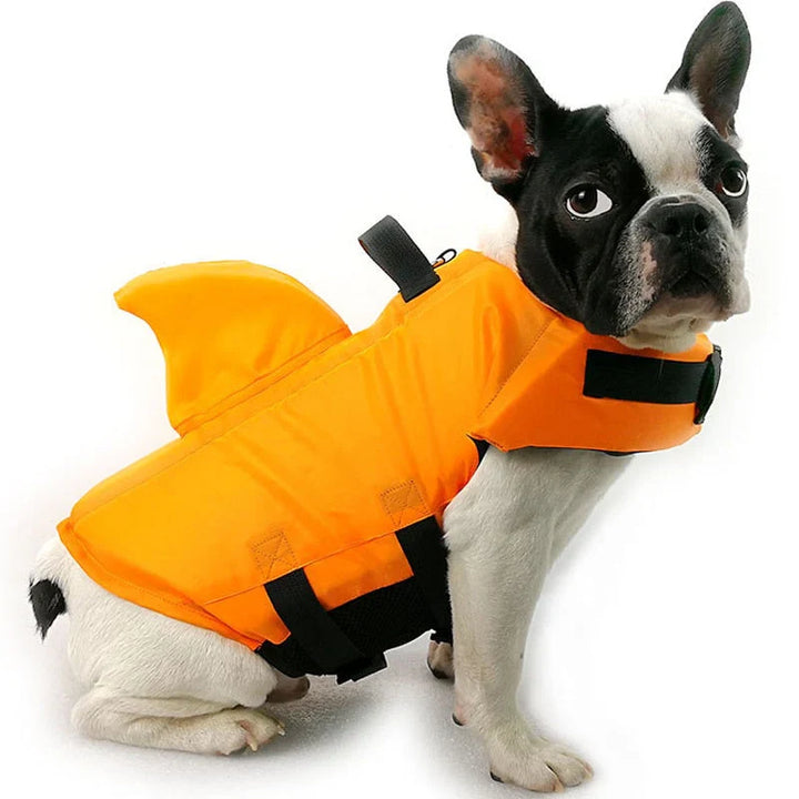 Hundesvømmevest med hajfinne i blåt stof, justerbare stropper for optimal sikkerhed i vandet, egnet til hunde i alle størrelser.