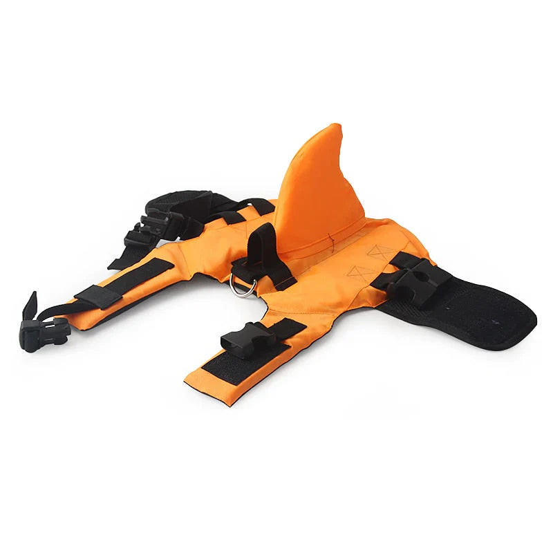 Hundesvømmevest med hajfinne i blåt stof, justerbare stropper for optimal sikkerhed i vandet, egnet til hunde i alle størrelser.