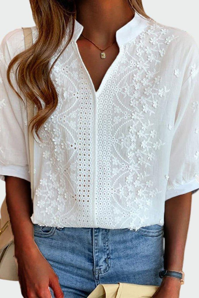 Hvid, let broderet damebluse med korte ærmer og afslappet pasform, perfekt som elegant sommerbluse.