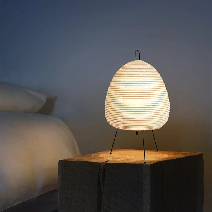 Japansk bordlampe af rispapir, udsender varmt, diffust lys, elegant og tidløst design til indretning.