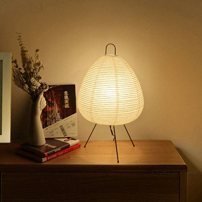 Japansk bordlampe af rispapir, udsender varmt, diffust lys, elegant og tidløst design til indretning.