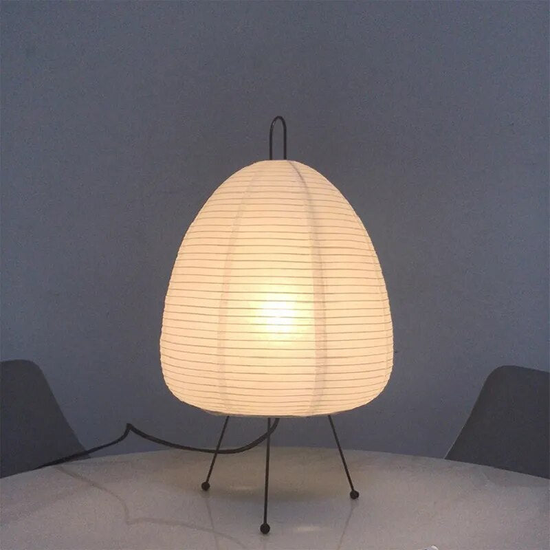 Japansk bordlampe af rispapir, udsender varmt, diffust lys, elegant og tidløst design til indretning.