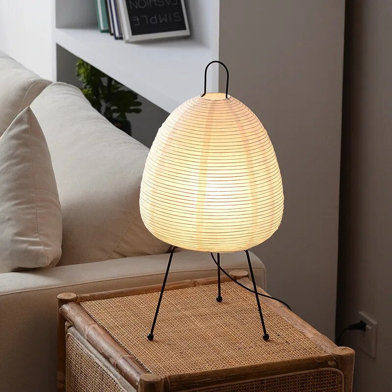 Japansk bordlampe af rispapir, udsender varmt, diffust lys, elegant og tidløst design til indretning.
