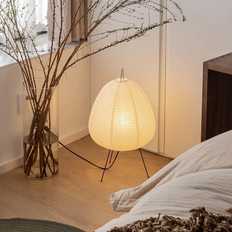Japansk bordlampe af rispapir, udsender varmt, diffust lys, elegant og tidløst design til indretning.
