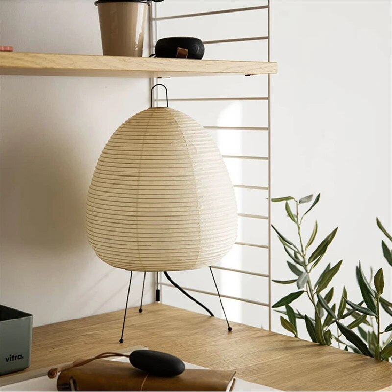 Japansk bordlampe af rispapir, udsender varmt, diffust lys, elegant og tidløst design til indretning.