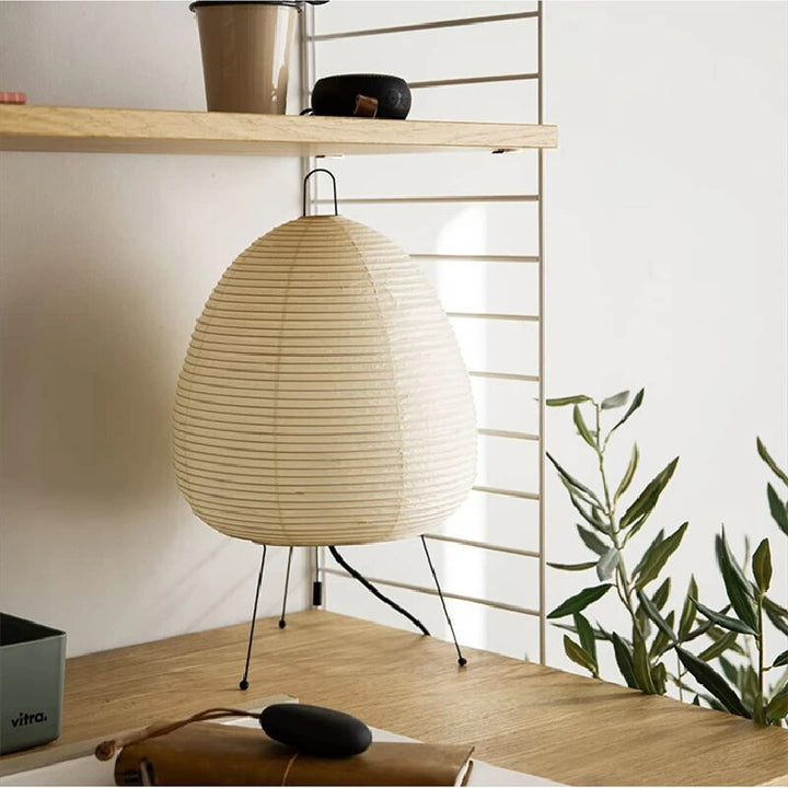 Japansk bordlampe af rispapir, udsender varmt, diffust lys, elegant og tidløst design til indretning.