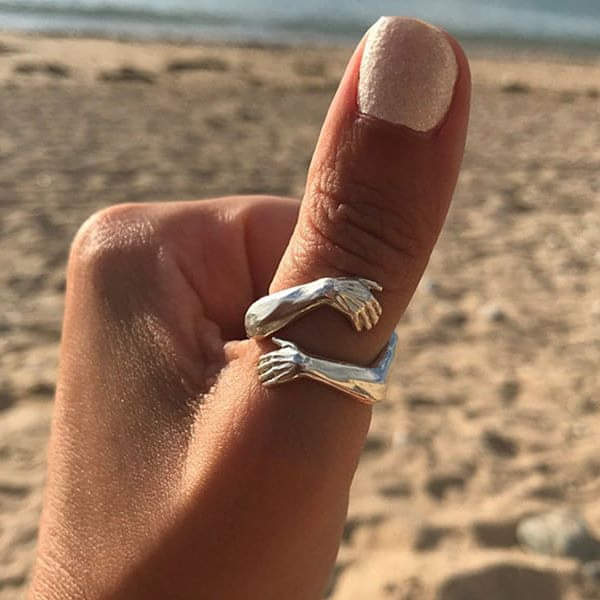 Justerbar sølvfarvet unisex krammering, der symboliserer kærlighed og omfavnelse. Perfekt som følelsesladet gave.