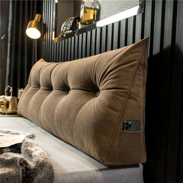 En person, der komfortabelt læser i sengen med EliteComfort kilepuden, viser dens ergonomiske design.