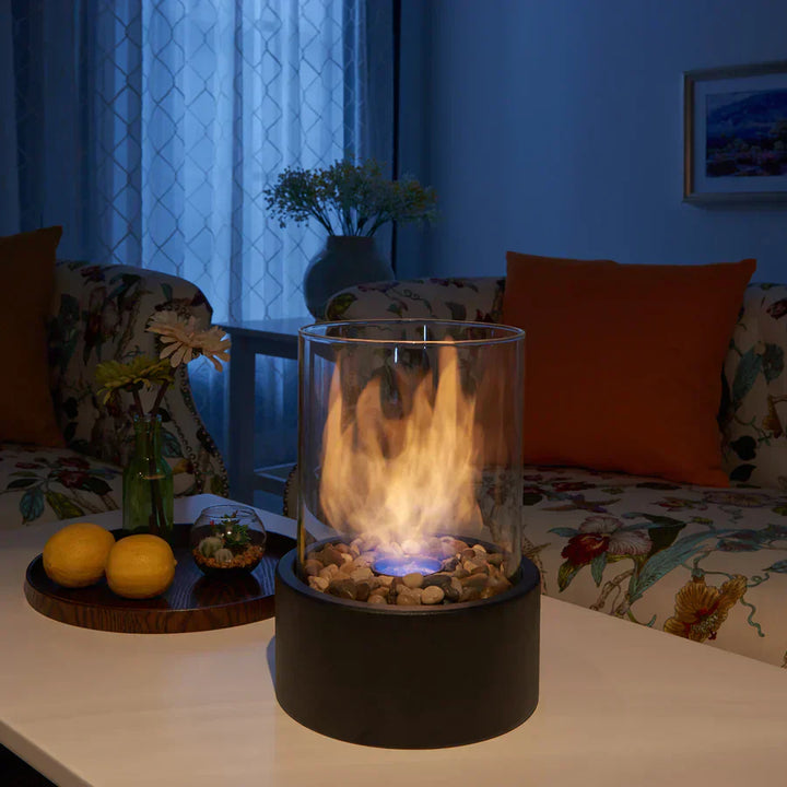 Kompakt bærbar pejs med moderne glasdesign, ideel til indendørs og udendørs brug, skaber en røgfri, hyggelig atmosfære.