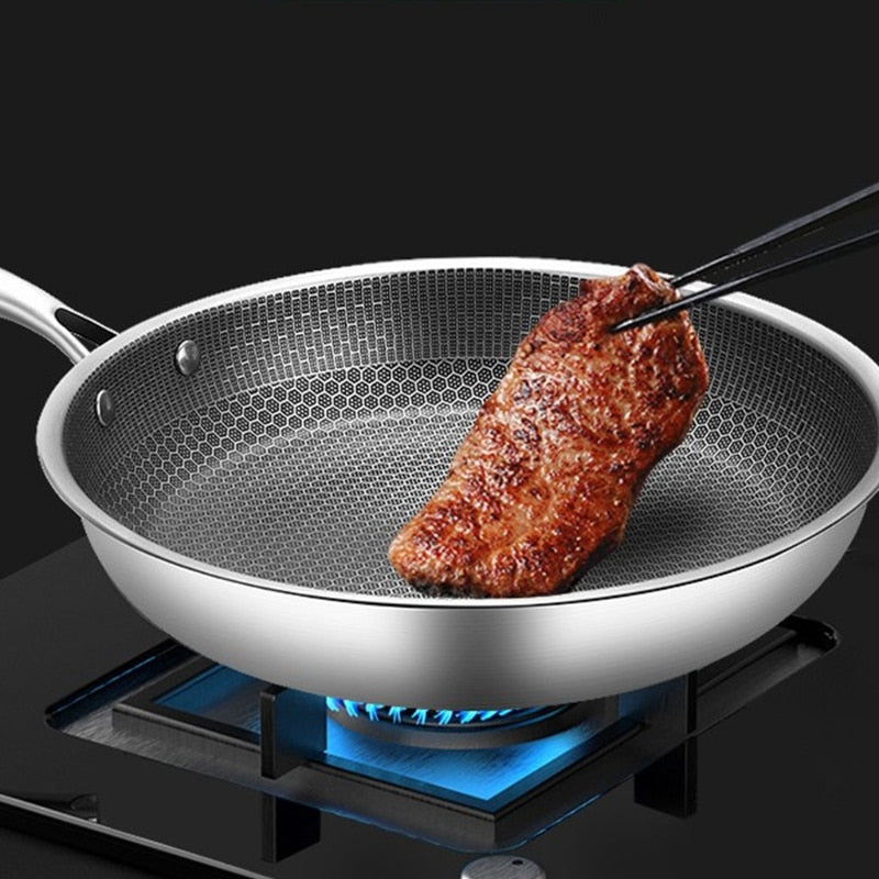 Ridsefast stegepande i rustfrit stål med non-stick belægning, ergonomisk håndtag og vaffelstruktur for jævn varmefordeling.