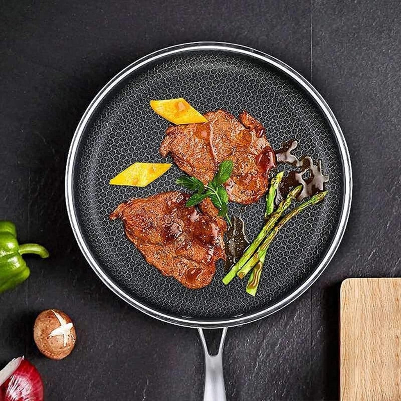 Ridsefast stegepande i rustfrit stål med non-stick belægning, ergonomisk håndtag og vaffelstruktur for jævn varmefordeling.