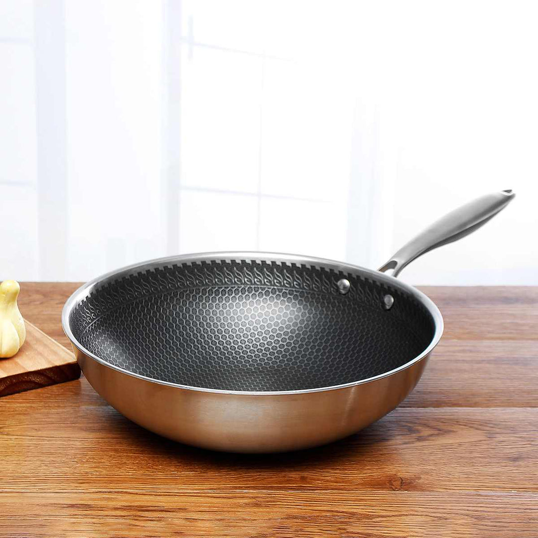 Ridsefast stegepande i rustfrit stål med non-stick belægning, ergonomisk håndtag og vaffelstruktur for jævn varmefordeling.