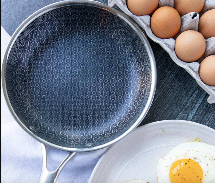 Ridsefast stegepande i rustfrit stål med non-stick belægning, ergonomisk håndtag og vaffelstruktur for jævn varmefordeling.