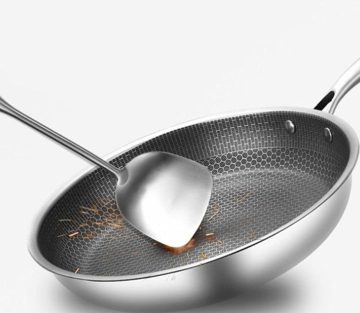 Ridsefast stegepande i rustfrit stål med non-stick belægning, ergonomisk håndtag og vaffelstruktur for jævn varmefordeling.