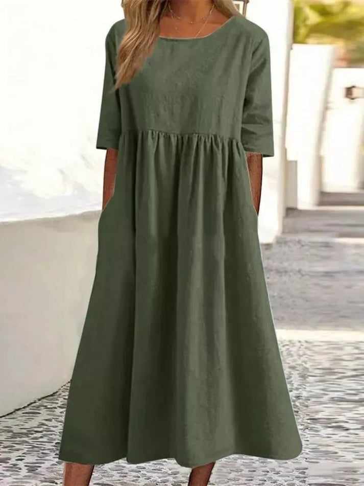 Feminin kvinde i en let og afslappet knapkjole. Stilfuld langkjole ideel til sommer og hverdag. Elegant maxikjole.