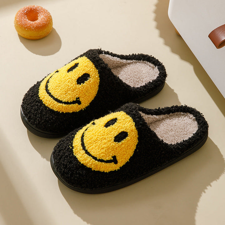 Sidebillede af kvindehjemmesko med plysforing, smilende ansigt og skridsikker sål. Ideel til hygge.