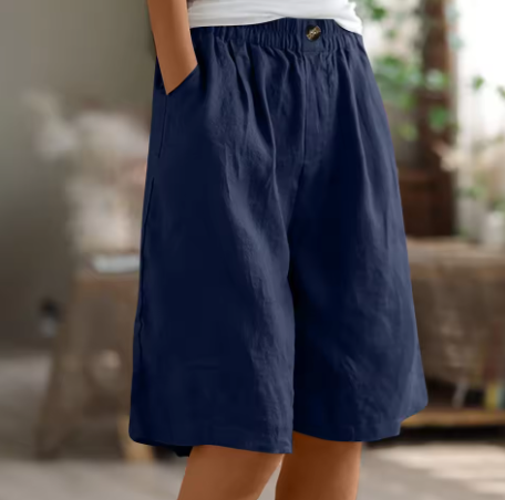 Bagside af lilla løse fritidsshorts med praktiske lommer, designet for afslappet sommerstil.