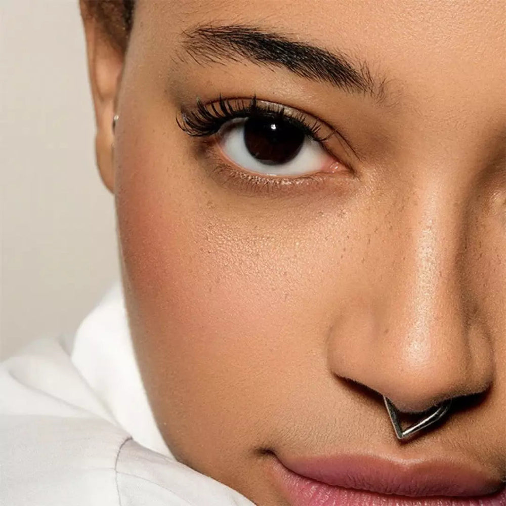 Model demonstrerer let påføring af genanvendelige magnetiske øjenvipper for naturligt look.
