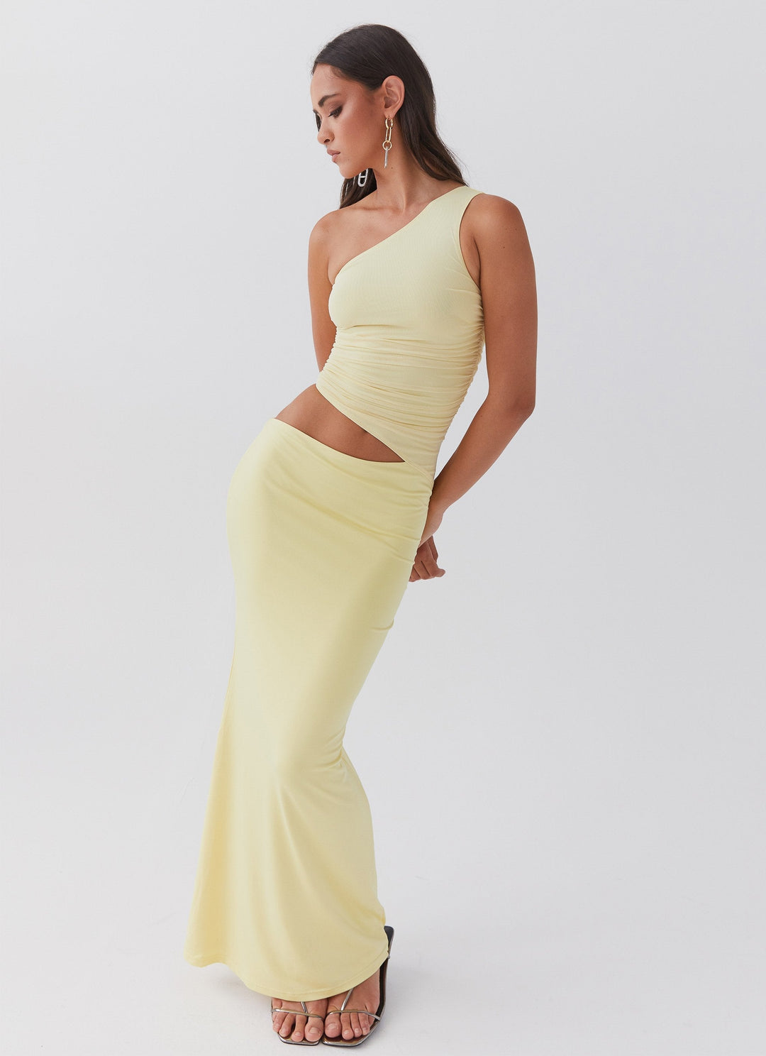 Lang aftenkjole til kvinder med one-shoulder og elegant cut-out detalje. Perfekt festkjole.