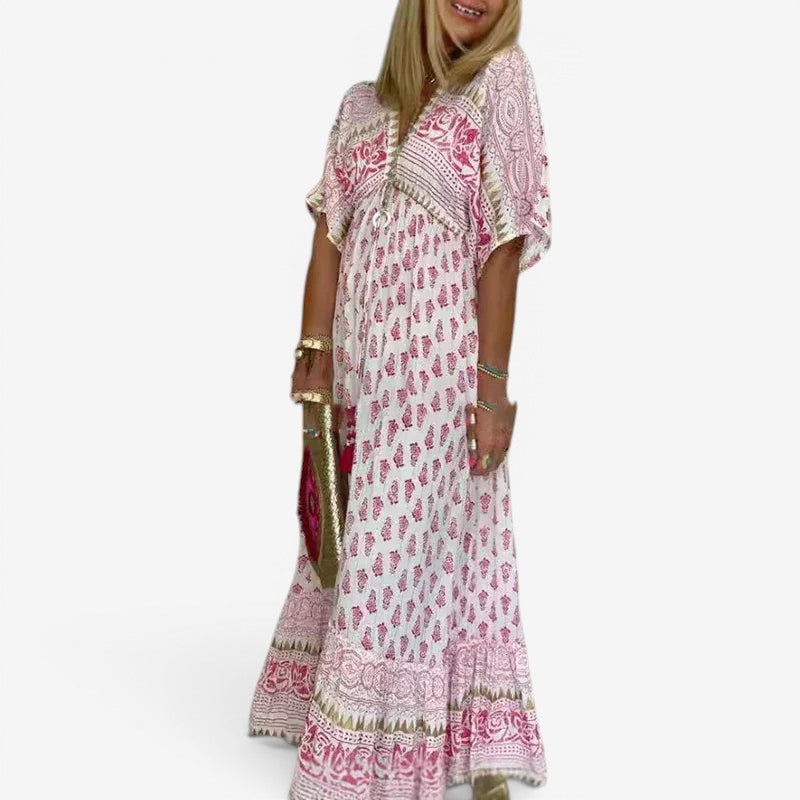 Lyserød dame maxikjole med løs pasform, elegant V-hals og dekorative kvaster, perfekt sommerkjole til ferie.