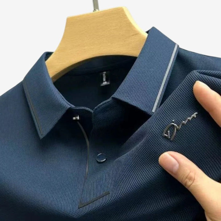 Mand iført afslappet kortærmet polo med stilfuldt print og klassisk knapkrave. Casual hverdagsstil.