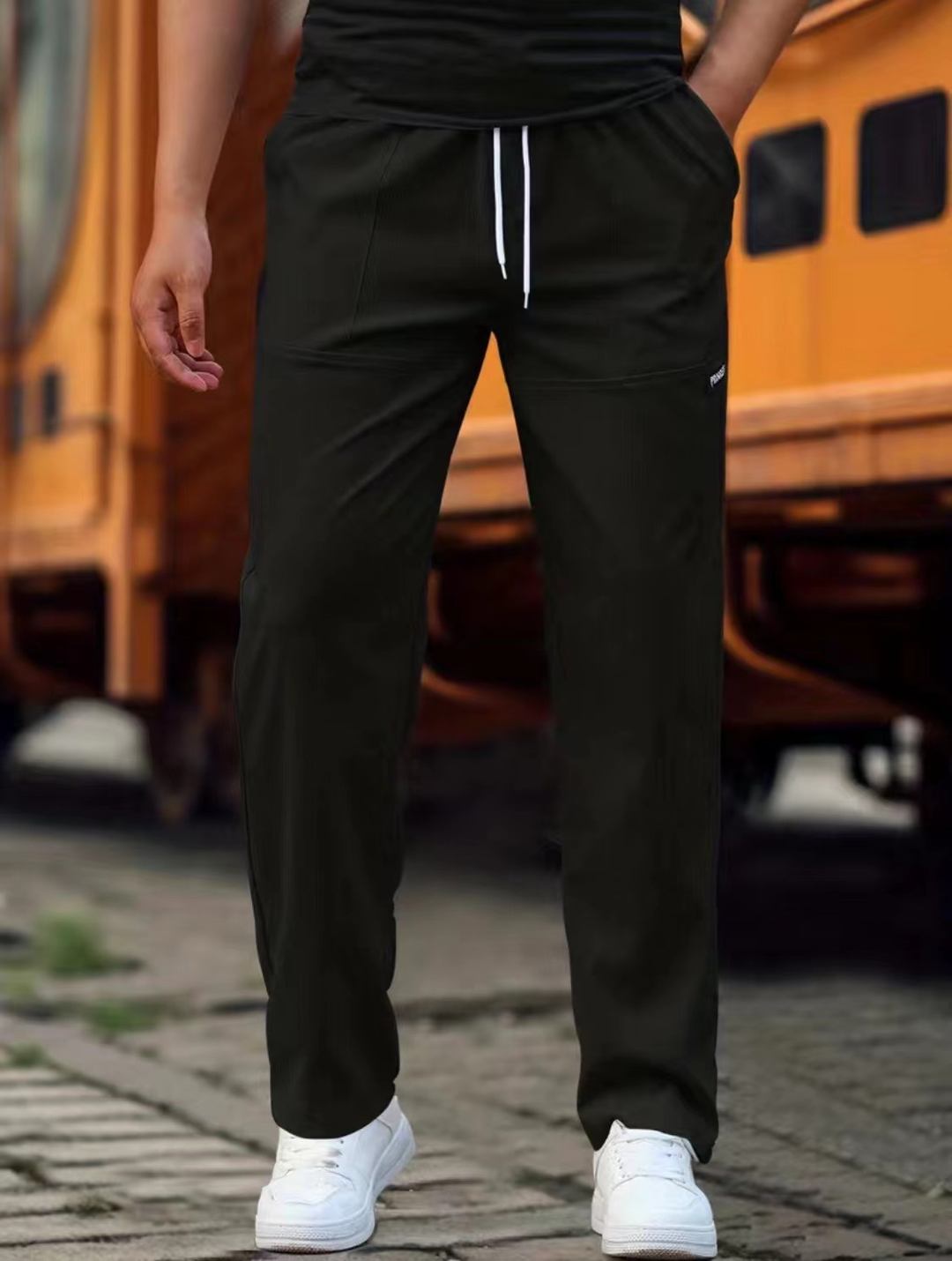 Detalje af ben på mænds komfortable joggingbukser, velegnet til stilfuldt sportstøj og fritidsbrug.