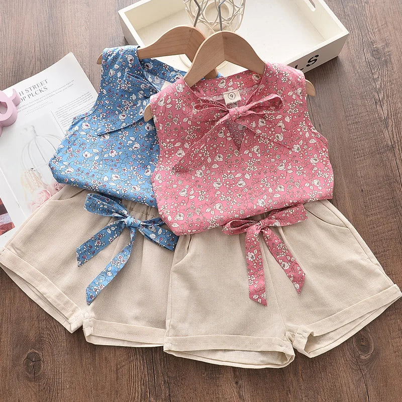 Pige sommerensemble, ærmeløs top med sløjfe, luftige shorts, blomstermønster, perfekt pasform til varme dage.