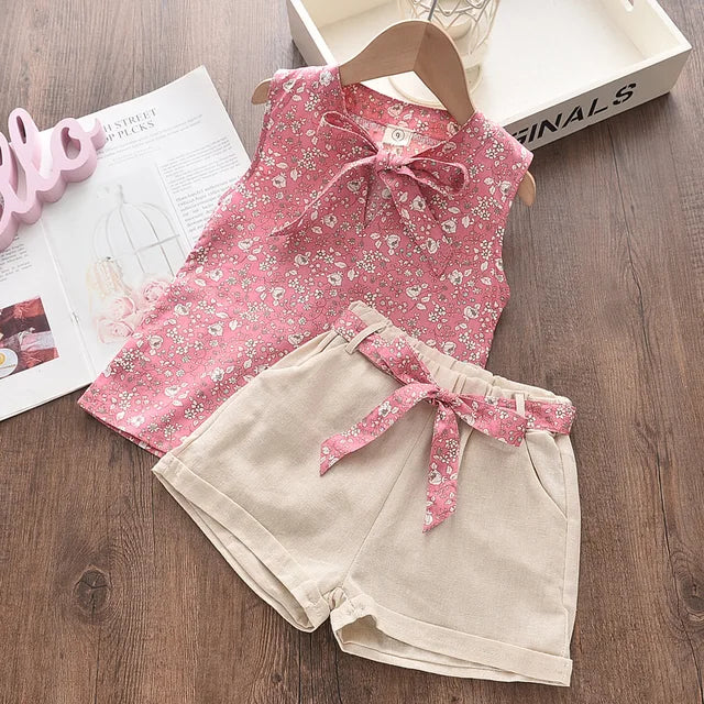 Pige sommerensemble, ærmeløs top med sløjfe, luftige shorts, blomstermønster, perfekt pasform til varme dage.