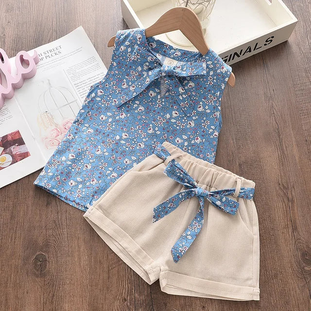 Pige sommerensemble, ærmeløs top med sløjfe, luftige shorts, blomstermønster, perfekt pasform til varme dage.