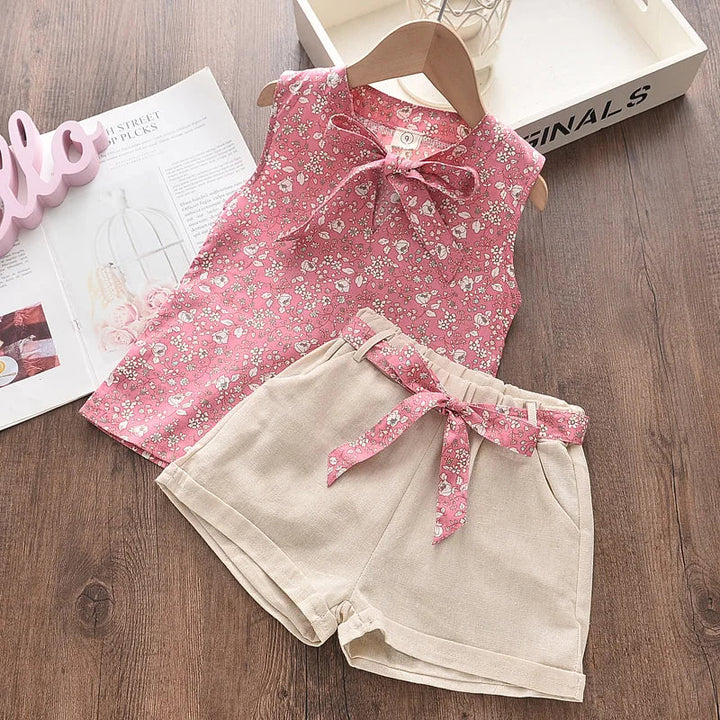 Pige sommerensemble, ærmeløs top med sløjfe, luftige shorts, blomstermønster, perfekt pasform til varme dage.