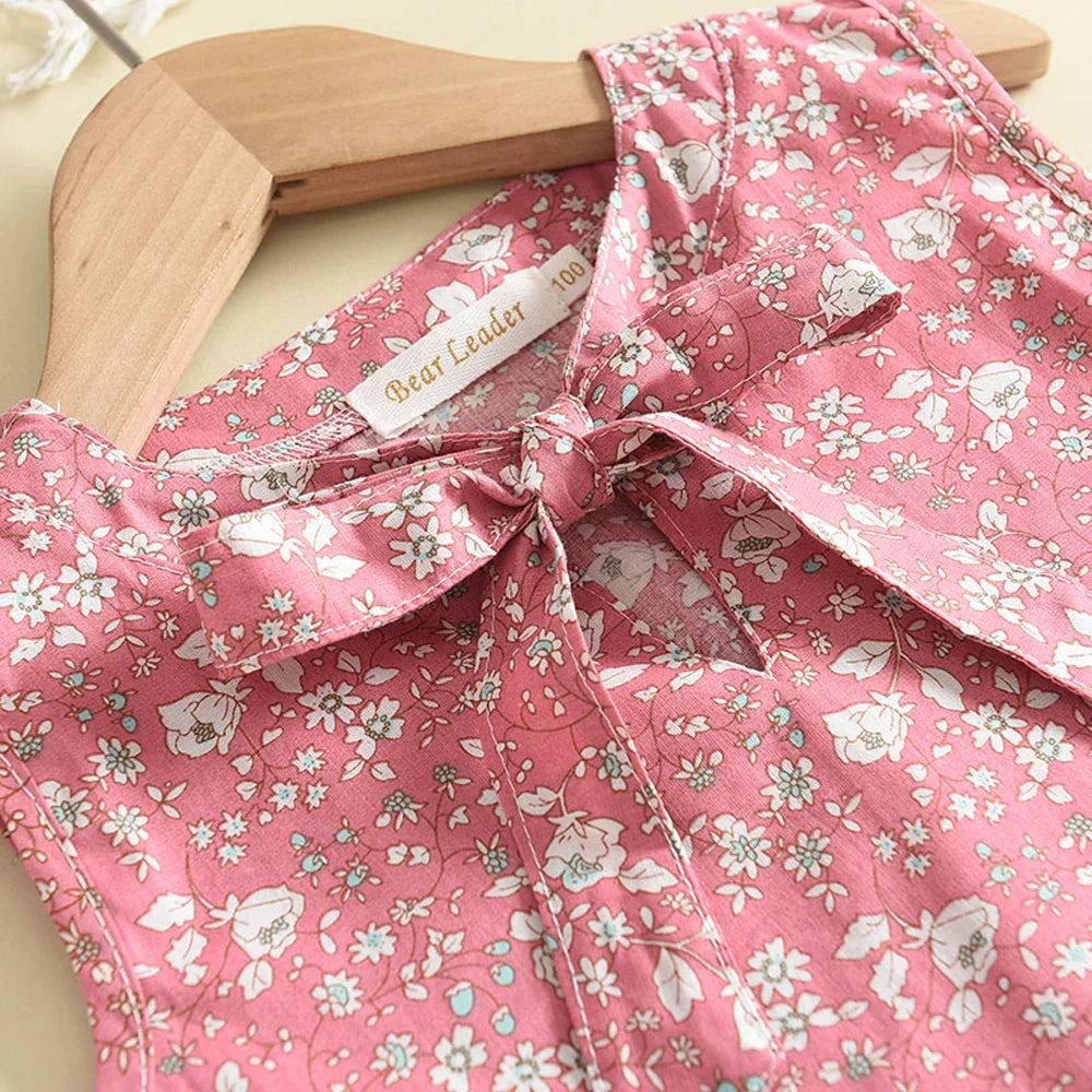Pige sommerensemble, ærmeløs top med sløjfe, luftige shorts, blomstermønster, perfekt pasform til varme dage.