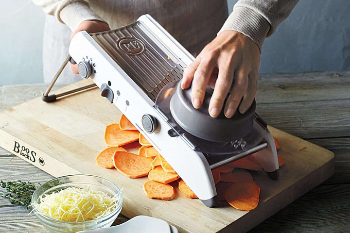Mandolin grøntsagsskærer med justerbare knive i rustfrit stål, ideel til præcis snit af grøntsager i forskellige tykkelser.