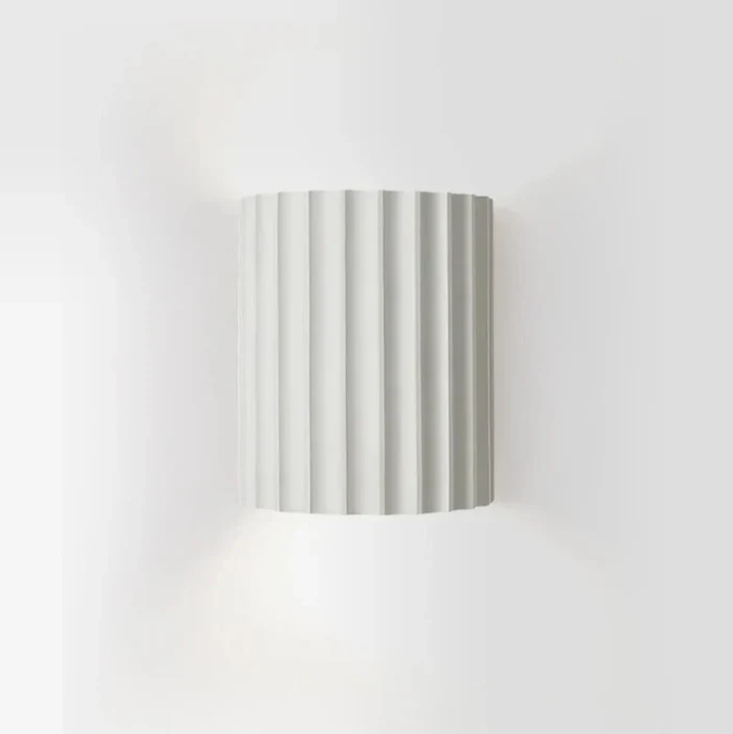 Moderne væglampe i harpiks med stilfuldt design og varmt lys, perfekt til skandinaviske og minimalistiske rum.