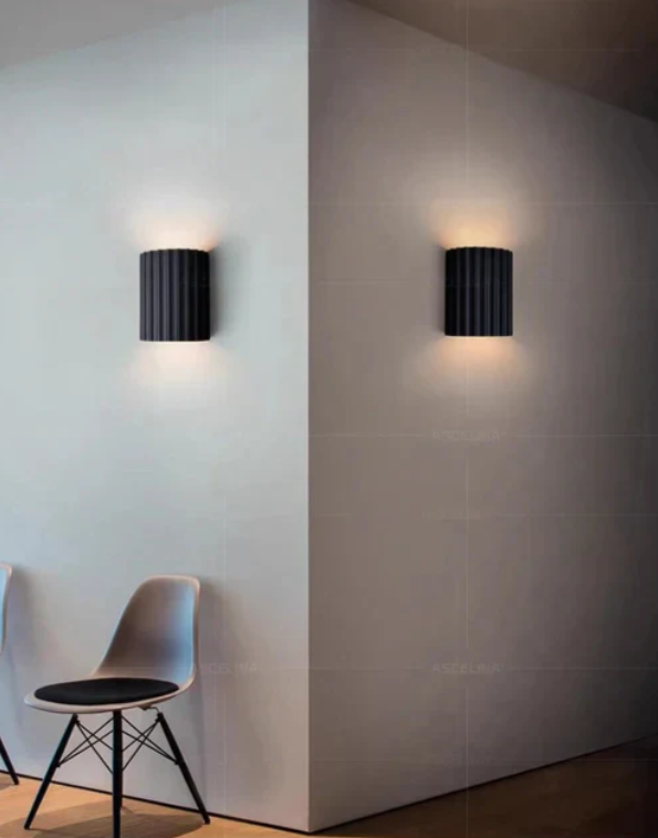 Moderne væglampe i harpiks med stilfuldt design og varmt lys, perfekt til skandinaviske og minimalistiske rum.