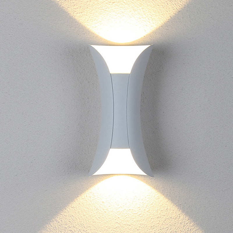 Detalje af moderne sort og guld LED væglampe, fremhæver designet for udendørs havebelysning.