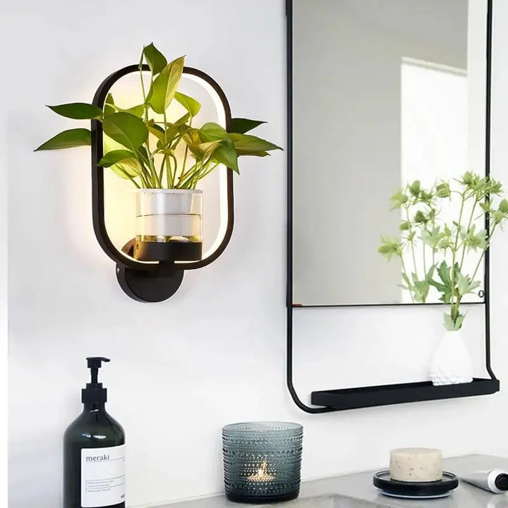 Moderne væglampe i glas og jern med integreret plantekasse, ideel til stuer og kontorer, stilfuldt design.