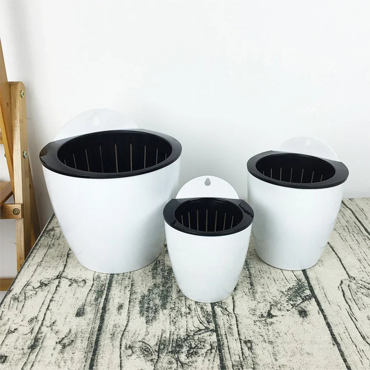 "Moderner, selbstbewässernder Hängepflanztopf mit stilvollem Design für Wandmontage – ideal für drinnen und draußen."