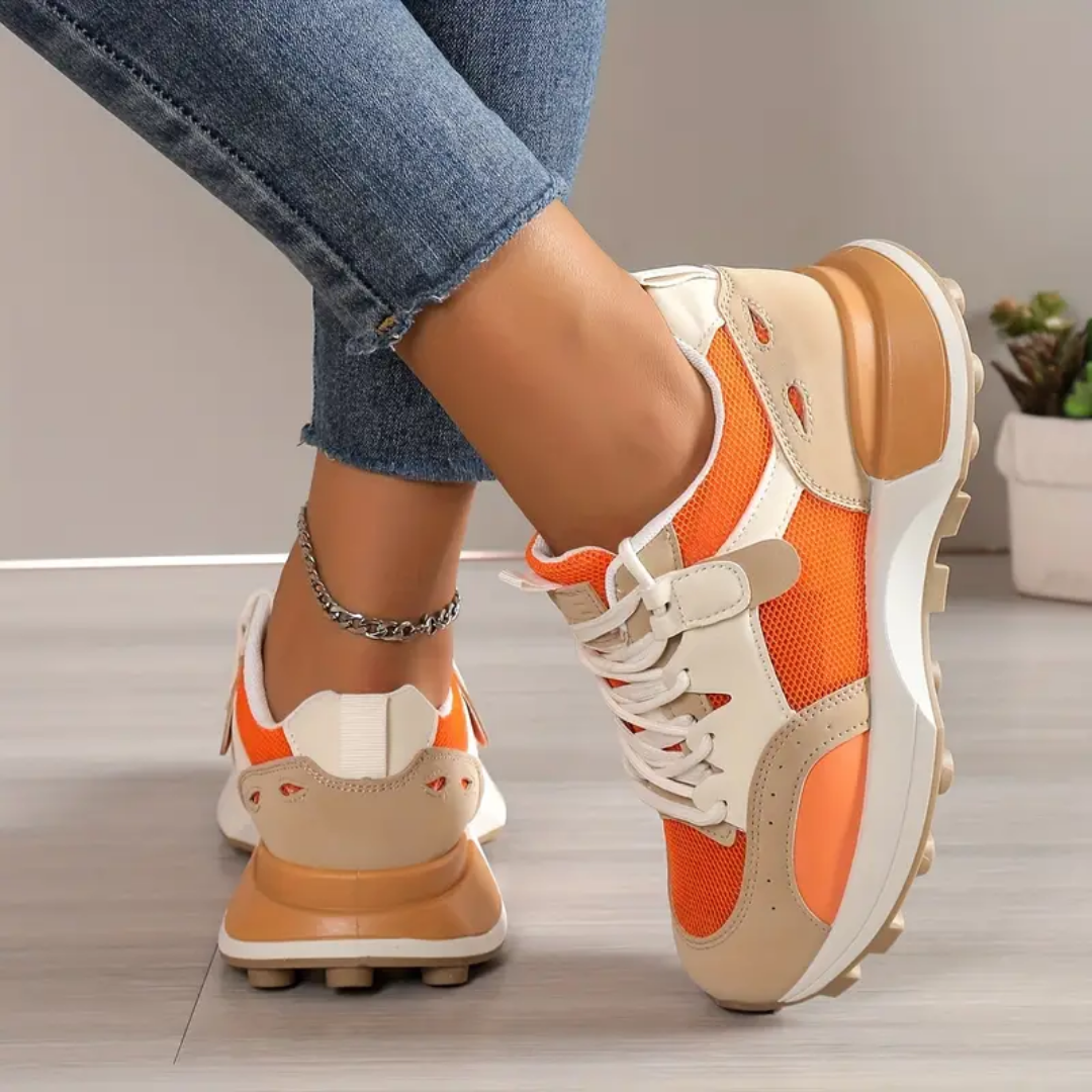 Nærbillede af orange damesneakers, fremviser letvægtsmateriale & komfortabel sål. Perfekt sommerfodtøj til kvinder.