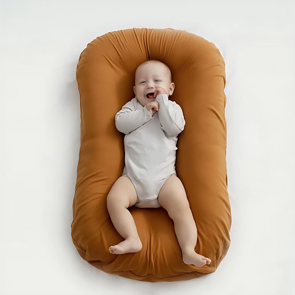 Ortopædisk babyhovedpude i beige, blød, optimalt støttende, lavet af åndbart materiale, passer til babysenge.