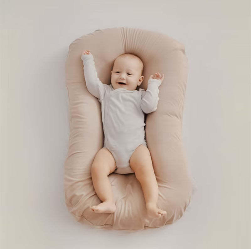 Ortopædisk babyhovedpude i beige, blød, optimalt støttende, lavet af åndbart materiale, passer til babysenge.