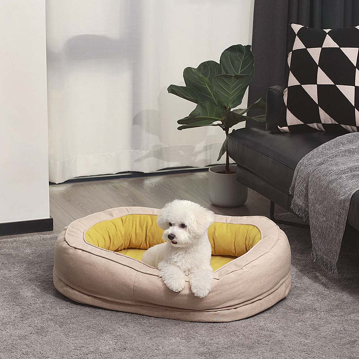 Ortopædisk fluffy kæledyrsseng i donutform, beige, til hunde, tilbyder komfort og støtte på glatte gulve.