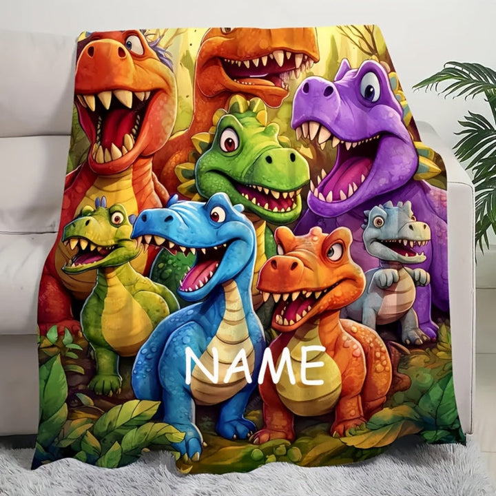Børnetæppe med dinosauere og navn, skaber hygge på værelset. Blødt flonel tæppe til leg og afslapning.