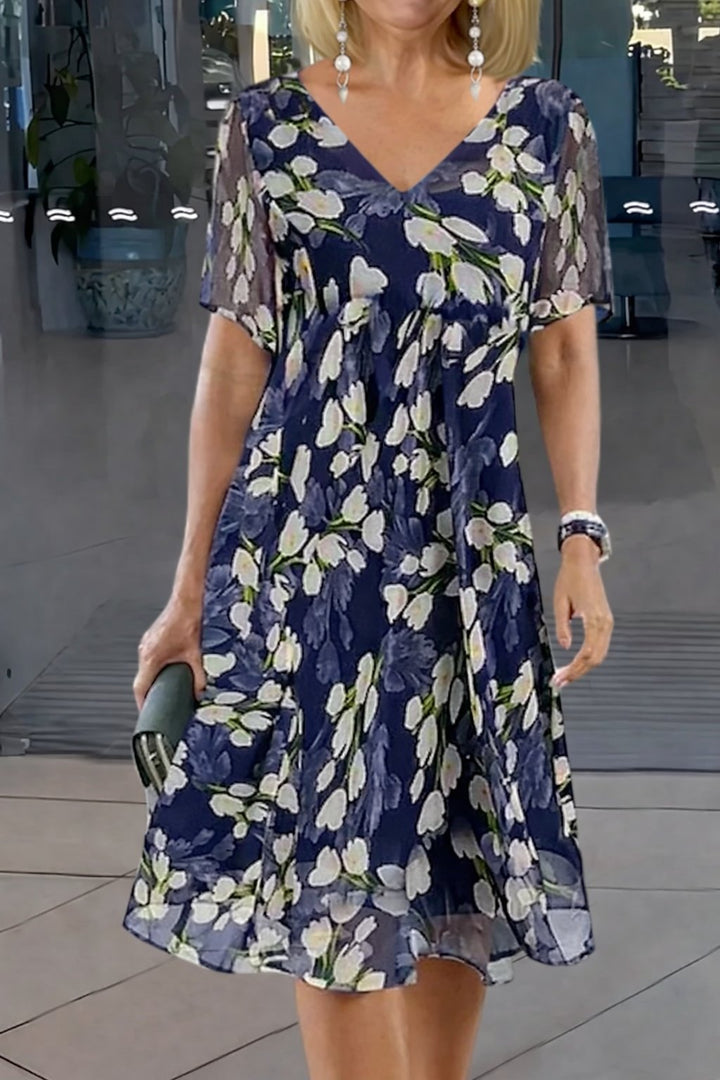 Plus size blomstret tunikakjole til kvinder med V-udskæring, kortærmet og løs pasform, i elegant marineblå.